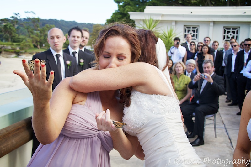 Bride and her sister hugging during ceremony in memory of their Mum - wedding photography sydney